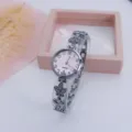 Detailed view of a stylish women's clover link quartz watch with a pink dial and silver band. - Silver Pink