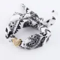 Detailed view of black and white paisley hair band with a sparkling rhinestone heart charm. - SB03-3 Black and White Paisley