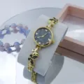 Gedetailleerde close-up van een gouden dames quartz horloge met stijlvolle vlinder strass armband. - Goud Zwart