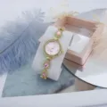 Detailed close-up shot of the elegant pink dial quartz watch with sparkling rhinestone bracelet. - Pink