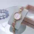 Gedetailleerd overzicht van dames roségoud quartz horloge met roze kristal vlinderarmband. - Roségoud roze