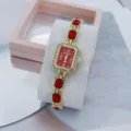 Detailansicht der luxuriösen Damen Quarz Armbanduhr mit rotem Kristallarmband und Strasssteinen. - Gold Rot