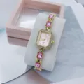 Detailansicht der goldenen Quarzuhr mit rosa Kristallen und elegantem Zifferblatt. - Gold & Rosa