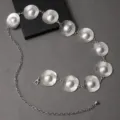 Vista de cerca de cadena de cintura redonda de metal plateado con detalle de perla elegante. - Plateado