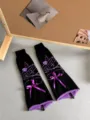 Gothic JK knit leg warmers with purple skull pattern and velvet bow detail close-up - Leg Warmers / Black Purple Drawstring Skull