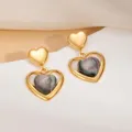 Vue détaillée de boucles d'oreilles cœur en acier titane et pierre œil de chat. - Boucles d'Oreilles Clous Cœur Incrusté Œil-de-Chat Noir