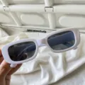 Nahaufnahme von weißen, retro rechteckigen Sonnenbrillen mit dunklen Gläsern im Streetwear-Look. - Gelee-Quadrat Weiß