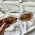 Retro rechteckige Sonnenbrille mit rosa Gestell und braunen Gläsern für trendige Streetwear. - Eckige Jelly-Sonnenbrille mit transparentem braunem Rahmen und braunen Gläsern