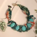 Macro view of ethnic printed fabric necklace with turquoise beads and golden bead clasp - X-895 Dark Green