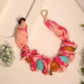 Macro view of floral print fabric and turquoise beads in creative necklace design - X-895 Rose Red