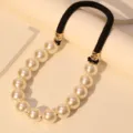 Close-up detail of luxury large pearl necklace with black cord and hammered gold accents - Necklace Only (X-783) / Milky White