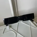 Nahaufnahme Detail von trendigen schwarzen schmalen Sonnenbrillen mit Perlenanhänger. - Schmaler Quadratischer Rahmentyp (Mit Wassertropfen-Perlenanhänger)