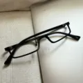 Detailaufnahme einer schwarzen Cyberpunk Unterhalb-Brille auf strukturierter Oberfläche. - Schwarz