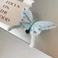 Detailaufnahme einer zarten Feder Schmetterlingshaarspange mit blauen Strasssteinen. - 1. Blauer Schmetterling aus echten Federn - Zerbrechlich