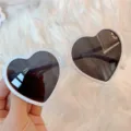 Nahaufnahme trendiger weißer Herz Sonnenbrillen mit dunklen Gläsern für süßen Retro Look. - Großes Herz weißer Rahmen schwarze Gläser