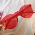 Nahaufnahme von halbdurchsichtigen rosa Sonnenbrillen mit trendigen Fassungsdetails. - Einteilig oval rosenrot