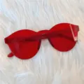 Modische rote rahmenlose Katzenaugen Sonnenbrille fuer Party und Streetwear Looks. - Ovales Monoglas Weinrot