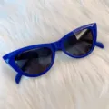 Detailansicht stylischer blauer Cateye Sonnenbrille mit glänzendem Gestell für Damen. - Dreieck königsblauer Rahmen schwarze Gläser