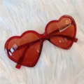 Rote herzförmige Sonnenbrille Detailaufnahme, modische Trend-Brille mit roten Gläsern. - Großes Herz - Weinrot