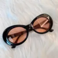 Retro Ovale Sonnenbrille mit dicken schwarzen Rahmen und rosa Gläsern für modischen Stil. - Runder Schwarzer Rahmen Rote Linse