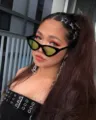 Nahaufnahme der modischen Retro-Cat-Eye-Sonnenbrille mit farbigen Gläsern für den Alltag. - Schwarzes Gestell mit gelben Gläsern