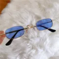 Detailaufnahme von kleinen eckigen Retro-Sonnenbrillen mit blauen Gläsern und Goldmetallrahmen. - Mini-Eckbrille mit blauen Gläsern
