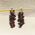 Vue détaillée de boucles d'oreilles pendantes en pierres de grenat rouge avec clous métalliques. - Pampille Pendante / Boucles d'Oreilles Clous Pendantes
