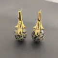Gros plan détaillé des boucles d'oreilles pendantes en pierre naturelle style bohème chic. - Pierre naturelle dalmate