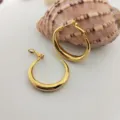 Vue détaillée de créoles dorées brillantes montrant la finition en métal poli et le fermoir. - 30mm Diamètre / Or