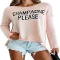 Close-up detail of the pink knit sweater featuring bold black slogan knit lettering. - Pink