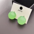 Petites boucles d'oreilles puces rondes vertes minimalistes avec carte de présentation. - Vert clair