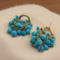 Gros plan de boucles d'oreilles vintage en turquoise, cerceau doré, détail de bijoux élégant. - Style de Raisin Vintage (DA260119) / Turquoise