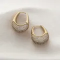 Gros plan détaillé de magnifiques boucles d'oreilles créoles plaquées or 18k avec zircons. - Or
