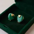 Gros plan de boucles d'oreilles cœur en texture malachite verte design plaqué or de luxe. - Malachite