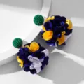 Macro view of handmade fabric flower ball earrings featuring vibrant blue and yellow petals. - Green floral head