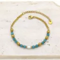 Close-up of gold titanium steel bracelet featuring blue natural stones and a white pearl. - Lake Blue