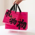 Rosa Papiertragetasche mit schwarzem Kalligrafietext und englischen Wünschen, große Tasche. - Geschenk / L / Rosa