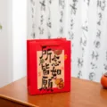 Rote Papiertragetasche mit chinesischer Kalligraphie und Festtagsmotiven für Neujahr, Geburtstag. - Was Du Denkst Wird Wahr (Mittel) / Weißer Karton