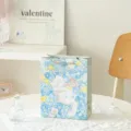 Süße Geschenktüte mit Blumen und weißer Katze, blaue Papiertüte für Geburtstage und schöne Präsente. - Freiheitsfantasie / S