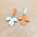 Dettaglio di orecchini pendenti floreali asimmetrici, design chic in metallo e resina. - Stile Fiore Asimmetrico (XL2176-01) / Arancione Bianco