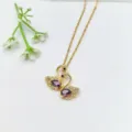 Primo piano della collana con ciondolo a doppio cigno, cristalli viola e dettagli oro. - Stile Doppio Cigno con Pietra a Goccia Viola (XL1548-5 Piccolo Cigno)