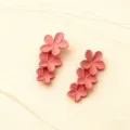 Dettaglio di orecchini pendenti con fiori rosa chic dal design floreale impilato. - Rosa chiaro