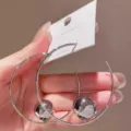 Vista dettagliata di orecchini a cerchio in argento con ciondolo a sfera, gioielli alla moda. - Argento