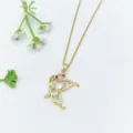 Primo piano dettagliato di una delicata collana con ciondolo a farfalla in oro e zirconi. - Stile Farfalla Zirconia Rossa (XL1200-356)