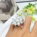 Primo piano dettagliato di un anello artigianale di perle con elegante design floreale. - Stile Aperto Mughetto in Perla Artificiale (XL2172-09)