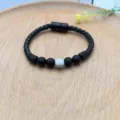 Vista dettagliata del bracciale in pelle intrecciata nera con chiusura magnetica e perle. - Pietra Lavica (XL0931-19)