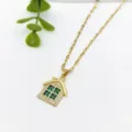 Dettaglio in primo piano della collana con ciondolo a casa d'oro con pietre verdi. - Casa con Finestra Verde (XL1200-230)