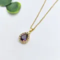Primo piano dettagliato di una collana con ciondolo in pietra viola a goccia lucente. - Stile Pietra Viola a Goccia (XL1200-1)