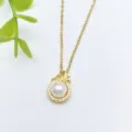 Elegante collana con ciondolo dorato con perla bianca centrale e pietre di zircone scintillanti. - Stile Perla Rotonda (XL1200-3)