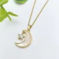 Primo piano di una elegante collana dorata con ciondolo a luna e stella in zircone. - Stile Stella e Luna in Madreperla (XL1200-11)